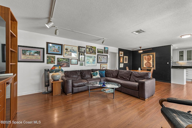 107 Algonquin Ter, Indian Harbour Beach, FL 32937 - living area featuring rail lighting, wood finished floors, a textured ceiling, baseboards, and ceiling fan