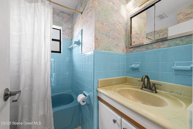 107 Algonquin Ter, Indian Harbour Beach, FL 32937 - bathroom featuring wallpapered walls, a wainscoted wall, shower / bath combo, vanity, and tile walls