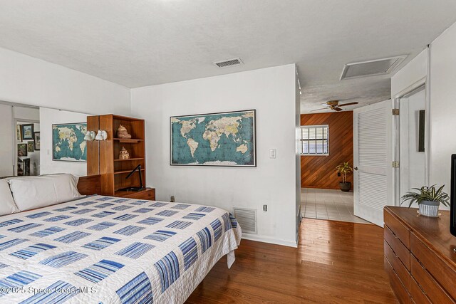 107 Algonquin Ter, Indian Harbour Beach, FL 32937 - bedroom with wood finished floors, wooden walls, baseboards, and attic access