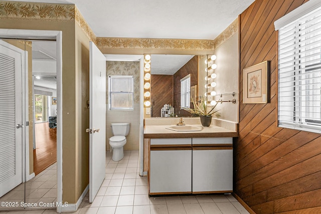 107 Algonquin Ter, Indian Harbour Beach, FL 32937 - bathroom featuring toilet, tile patterned floors, wood walls, and vanity