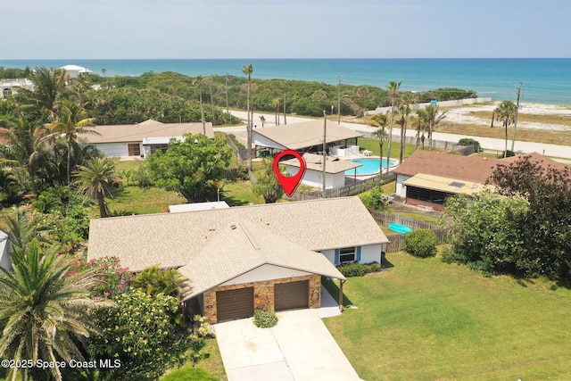 aerial view of property and surrounding area featuring a large body of water and a pool area