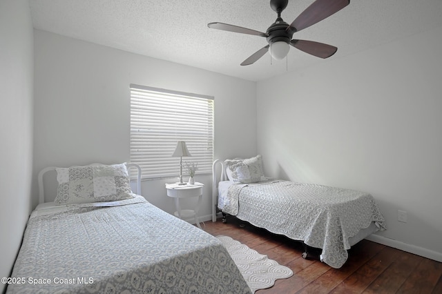 bedroom with wood finished floors, baseboards, ceiling fan, and a textured ceiling