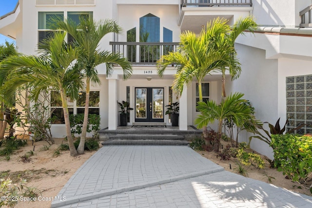 1495 Newfound Harbor Dr, Merritt Island, FL 32952 - property entrance with french doors, stucco siding, and a balcony