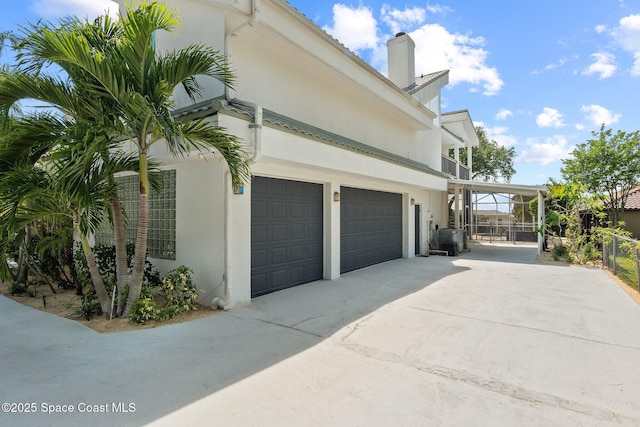 1495 Newfound Harbor Dr, Merritt Island, FL 32952 - view of home's exterior with fence, a garage, stucco siding, a chimney, and driveway