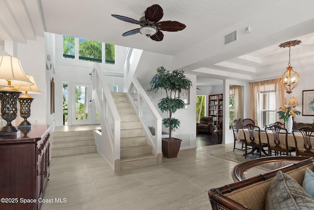 1495 Newfound Harbor Dr, Merritt Island, FL 32952 - stairs with visible vents, ceiling fan with notable chandelier, and a healthy amount of sunlight