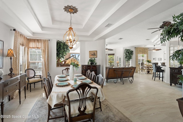 1495 Newfound Harbor Dr, Merritt Island, FL 32952 - dining area featuring a tray ceiling, visible vents, and ceiling fan with notable chandelier