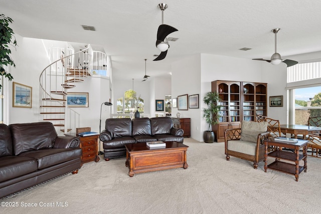 1495 Newfound Harbor Dr, Merritt Island, FL 32952 - living room featuring ceiling fan, visible vents, carpet floors, a high ceiling, and stairs