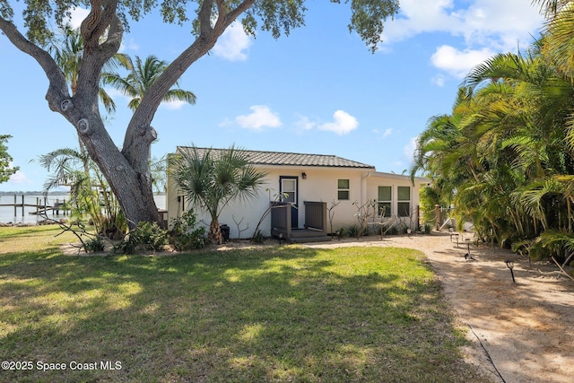 1495 Newfound Harbor Dr, Merritt Island, FL 32952 - rear view of house with a lawn, a tile roof, and stucco siding