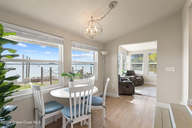 1495 Newfound Harbor Dr, Merritt Island, FL 32952 - dining room with plenty of natural light, a water view, light wood-style flooring, a notable chandelier, and vaulted ceiling