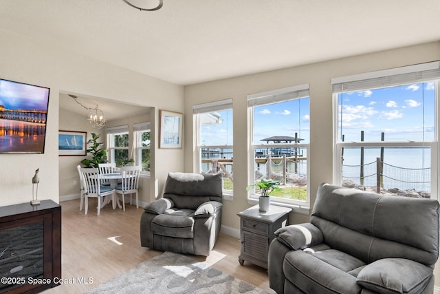 1495 Newfound Harbor Dr, Merritt Island, FL 32952 - living area featuring baseboards, a water view, light wood finished floors, and a chandelier