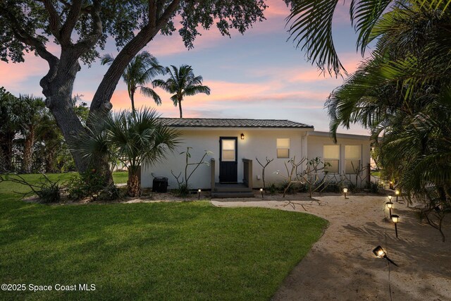 1495 Newfound Harbor Dr, Merritt Island, FL 32952 - view of front of property with central AC, a front lawn, stucco siding, and a tile roof