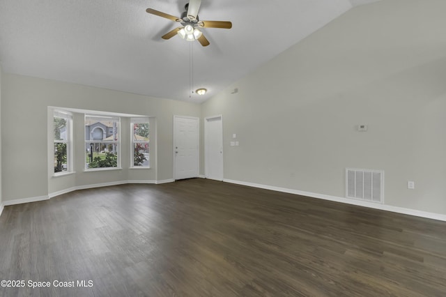 unfurnished living room featuring a ceiling fan, baseboards, vaulted ceiling, dark wood-type flooring, and visible vents