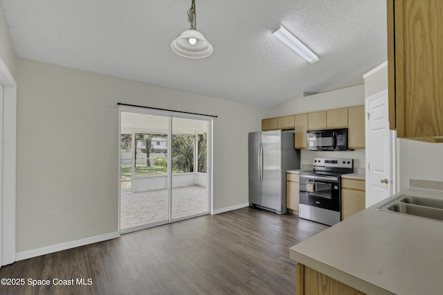 kitchen with a textured ceiling, light brown cabinetry, appliances with stainless steel finishes, light countertops, and lofted ceiling