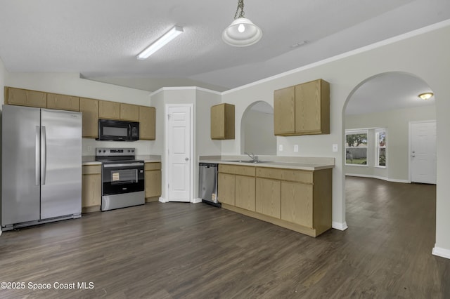 kitchen featuring appliances with stainless steel finishes, arched walkways, vaulted ceiling, light countertops, and dark wood-type flooring