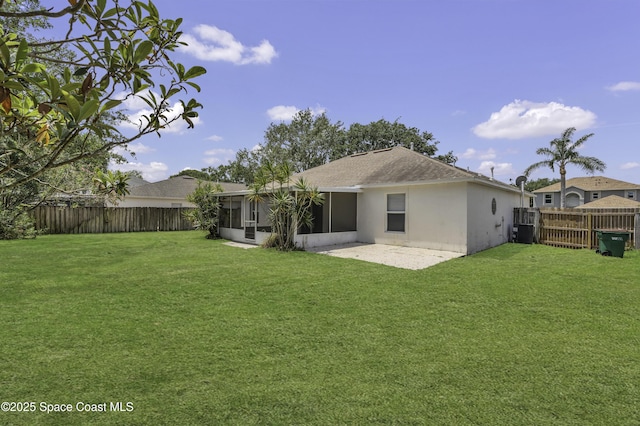 rear view of property featuring a sunroom, a fenced backyard, stucco siding, and a yard