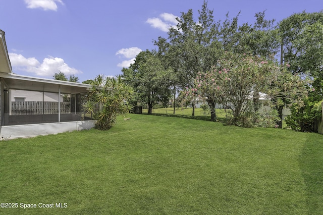 view of yard with fence and a sunroom