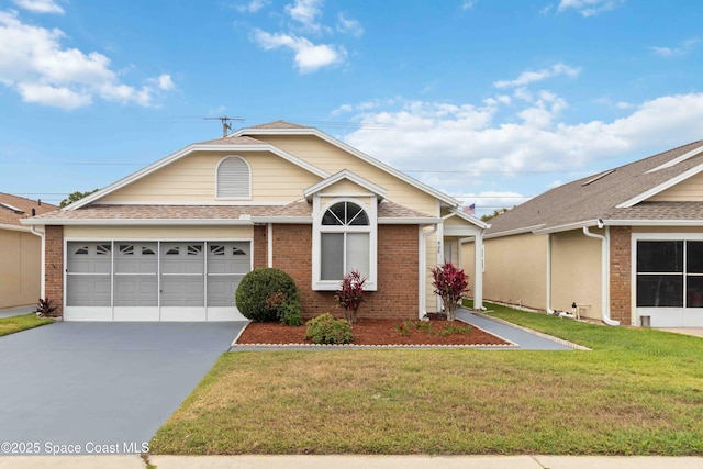 single story home with brick siding, driveway, a front yard, and a garage