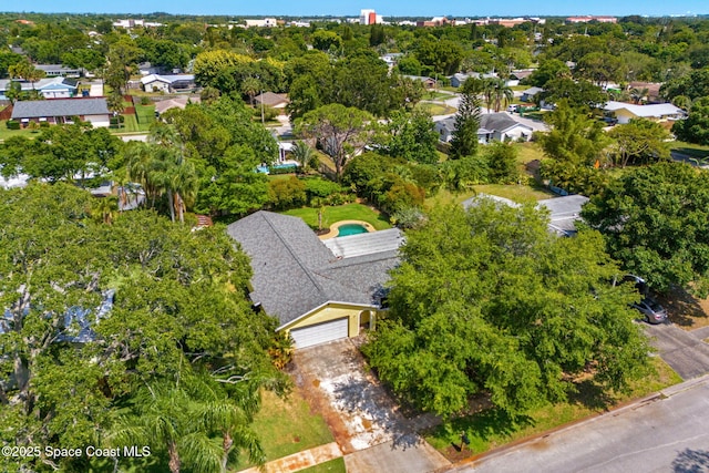 aerial overview of property's location featuring a tree filled landscape and nearby suburban area