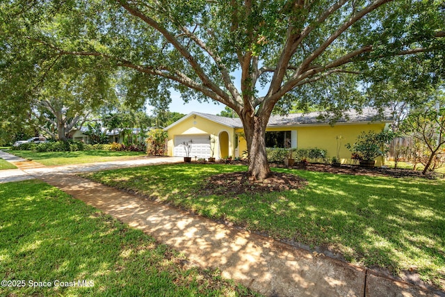 single story home featuring driveway, a garage, a front lawn, and stucco siding