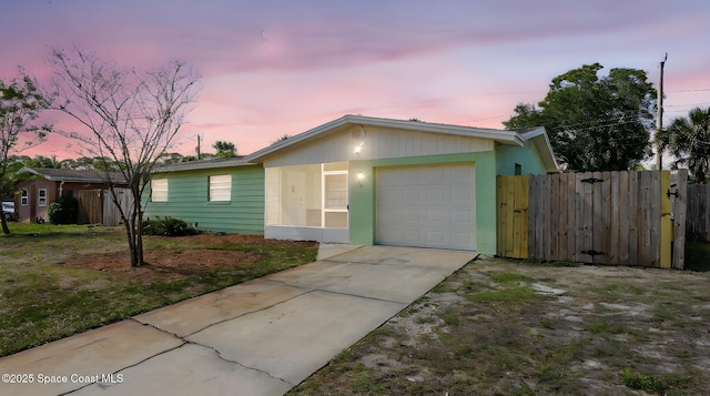 ranch-style home featuring a garage, fence, and concrete driveway