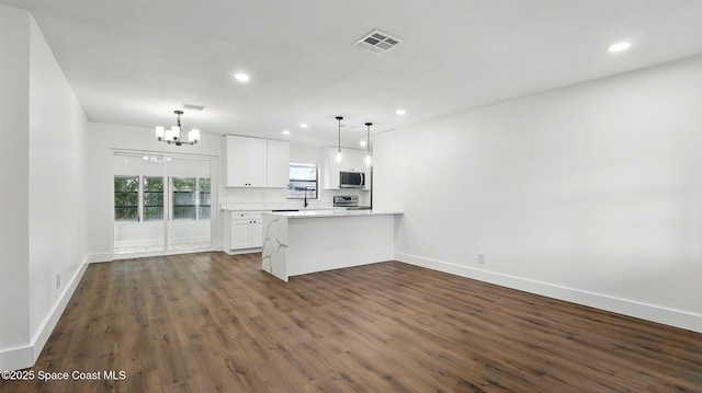 kitchen with a notable chandelier, appliances with stainless steel finishes, baseboards, visible vents, and dark wood-style floors
