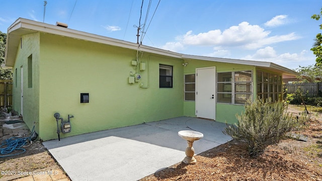 back of house with a patio, fence, a sunroom, and stucco siding