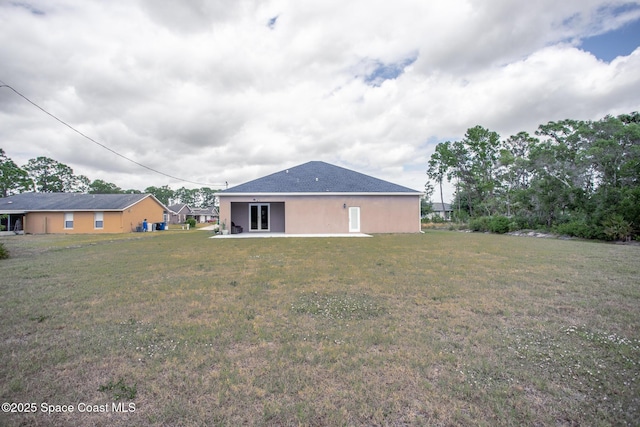 back of property featuring a lawn and a patio