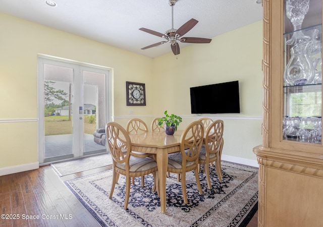 dining room featuring baseboards, a ceiling fan, and wood finished floors