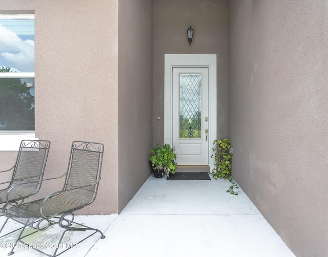 property entrance with stucco siding