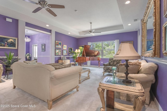 living room featuring light colored carpet, a raised ceiling, a ceiling fan, recessed lighting, and visible vents
