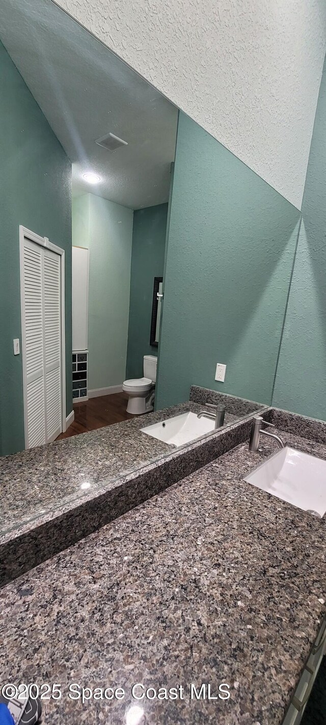 1662 Ricardo St SE, Palm Bay, FL 32909 - bathroom view of toilet, wood finished floors, and double vanity
