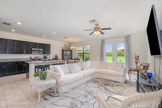 10033 W Verona Cir, Vero Beach, FL 32966 - living area featuring visible vents, recessed lighting, ceiling fan with notable chandelier, and light tile patterned flooring