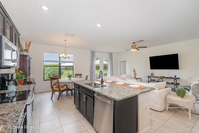 10033 W Verona Cir, Vero Beach, FL 32966 - kitchen featuring hanging light fixtures, a sink, light tile patterned floors, light stone counters, and stainless steel appliances