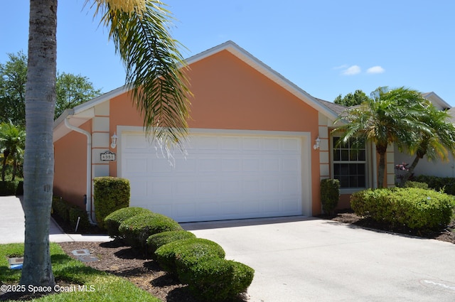 view of front of house featuring an attached garage, stucco siding, and driveway