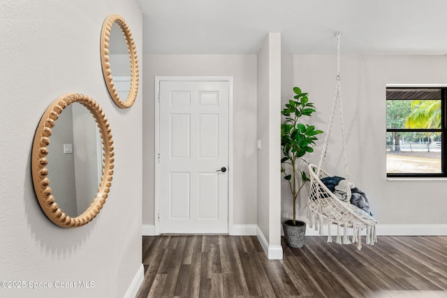 foyer entrance featuring baseboards and wood finished floors