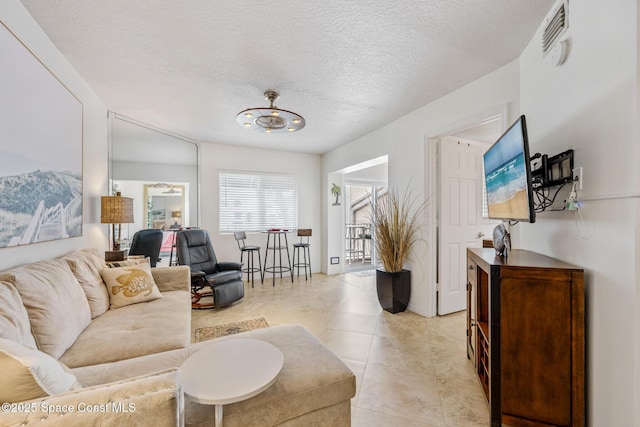 8600 Ridgewood Ave Unit 1208, Cape Canaveral, FL 32920 - living area with a chandelier, a textured ceiling, visible vents, and light tile patterned floors