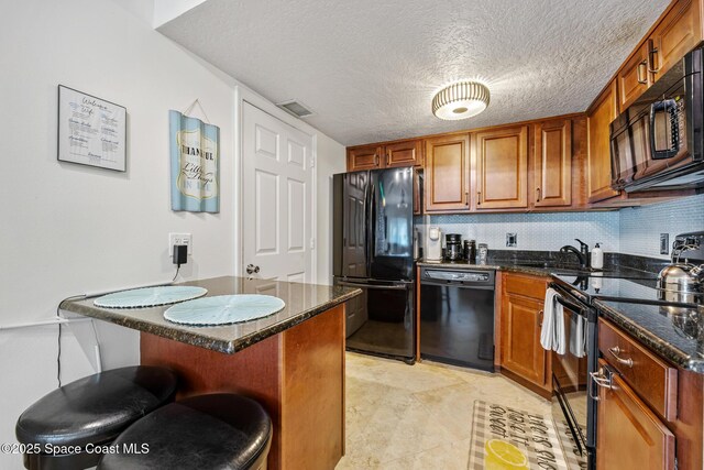 8600 Ridgewood Ave Unit 1208, Cape Canaveral, FL 32920 - kitchen with brown cabinets, a breakfast bar area, black appliances, and dark stone countertops