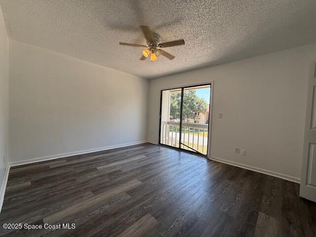 spare room with baseboards, a ceiling fan, a textured ceiling, and dark wood-style floors