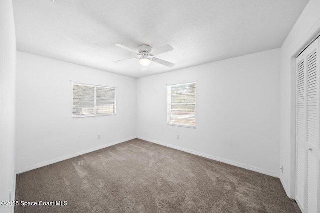 unfurnished bedroom with a closet, a ceiling fan, baseboards, and carpet floors
