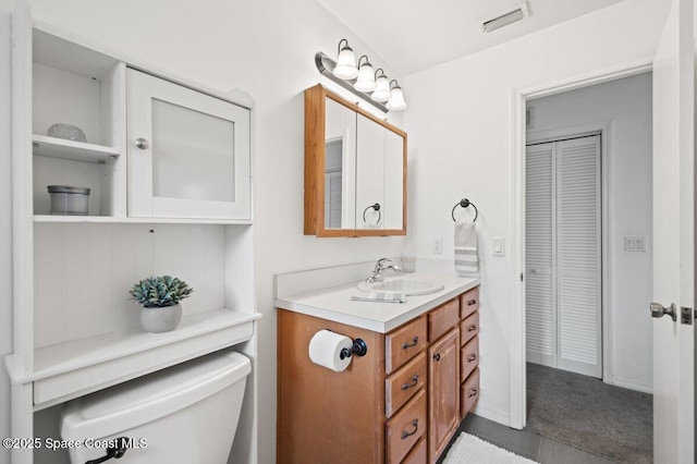 bathroom featuring vanity, visible vents, and toilet