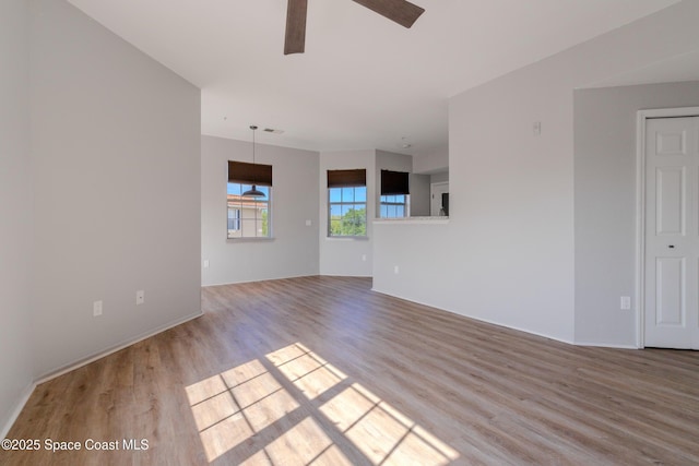 unfurnished living room with baseboards, a ceiling fan, wood finished floors, and visible vents