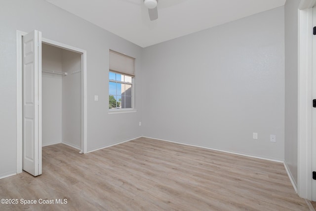 unfurnished bedroom with light wood-type flooring, baseboards, ceiling fan, and a closet