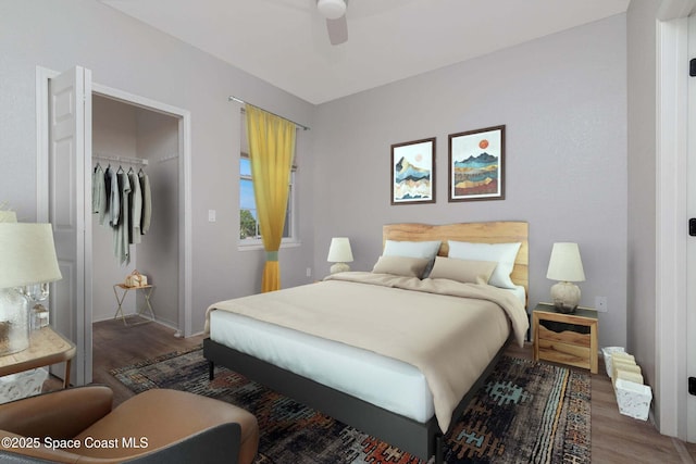 bedroom with a ceiling fan, baseboards, wood finished floors, and a closet