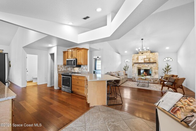 4730 Seminole Trl, Merritt Island, FL 32953 - kitchen with visible vents, appliances with stainless steel finishes, a peninsula, lofted ceiling, and a breakfast bar