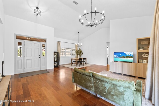 4730 Seminole Trl, Merritt Island, FL 32953 - living room featuring an inviting chandelier, high vaulted ceiling, baseboards, wood finished floors, and visible vents