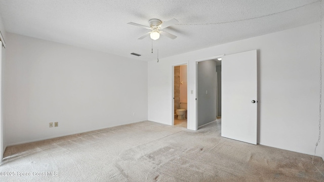 unfurnished bedroom with ceiling fan, visible vents, light carpet, and ensuite bathroom