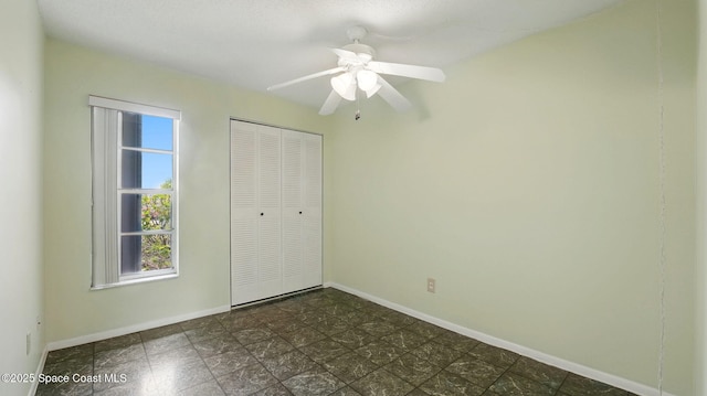 unfurnished bedroom with a closet, a ceiling fan, and baseboards