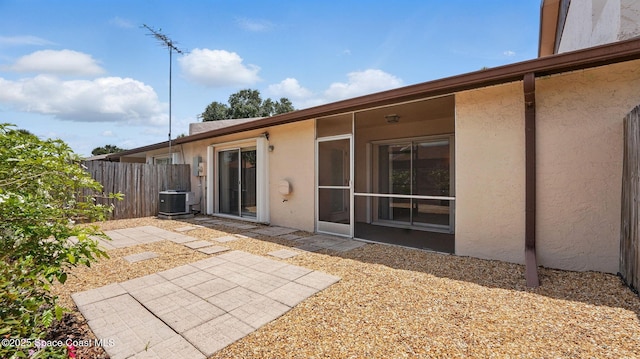 back of property featuring a patio, central AC, fence, and stucco siding