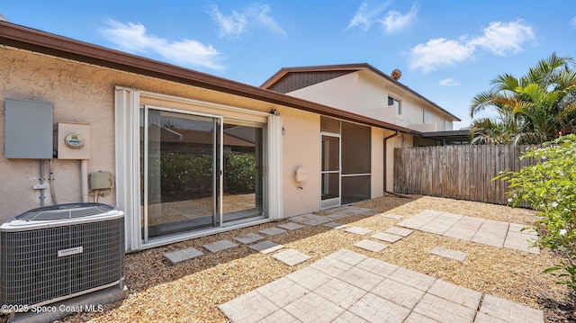 rear view of house featuring central AC, fence, a patio area, and stucco siding
