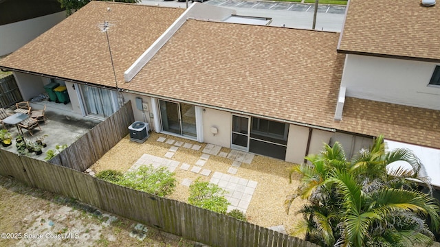 back of house featuring a patio, a shingled roof, and a fenced backyard